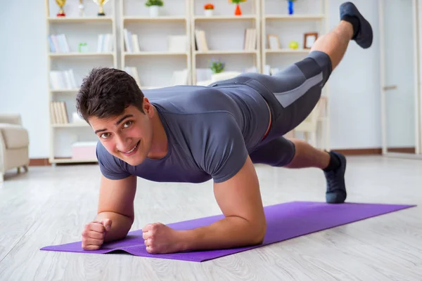 Junger Mann trainiert zu Hause mit Sport und gesundem Lebensstil — Stockfoto