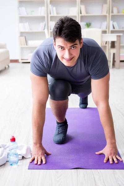 Ung man tränar hemma i idrott och hälsosam livsstil con — Stockfoto