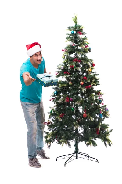 Genç adam beyaz üzerine izole edilmiş noel ağacını süslüyor.