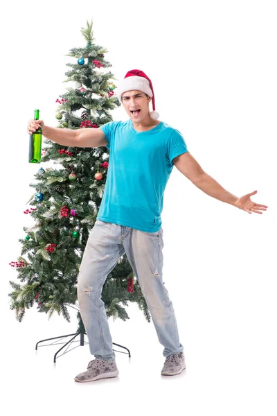 Genç adam beyaz üzerine izole edilmiş noel ağacını süslüyor.