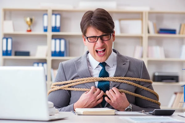 Businessman tied up with rope in office — Stock Photo, Image