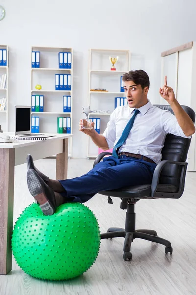 Joven empresario haciendo deporte estiramiento en el lugar de trabajo — Foto de Stock