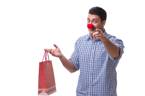 El hombre con una nariz roja divertida sosteniendo un regalo de bolsa de compras es —  Fotos de Stock