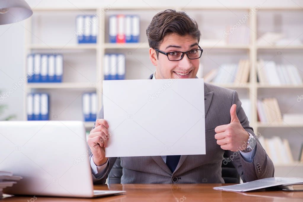 Businessman  in office holding a blank message board