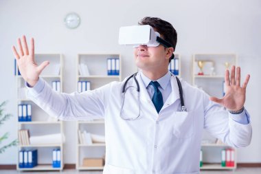 Sanal gerçeklik kulaklığı olan genç doktor ofiste çalışıyor.