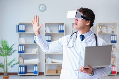 Sanal gerçeklik kulaklığı olan genç doktor ofiste çalışıyor.