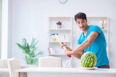 Evde karpuz yiyen bir adam.