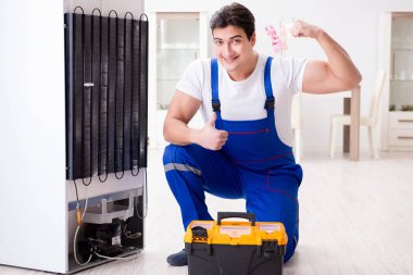 Tamirci müteahhit DIY konseptinde buzdolabını tamir ediyor.