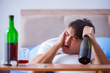 Yatakta içen alkolik adam depresyona giriyor.