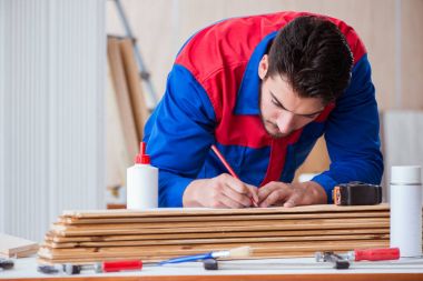 Yooung marangoz boyayla uğraşıyor.