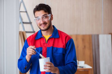 Yooung marangoz boyayla uğraşıyor.