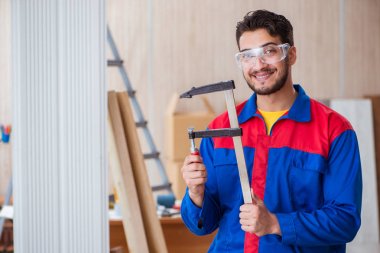 Klemplerle çalışan genç bir tamirci.