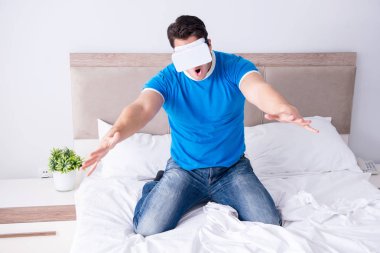 Yatakta sanal gerçeklik başlığı takan genç bir adam.