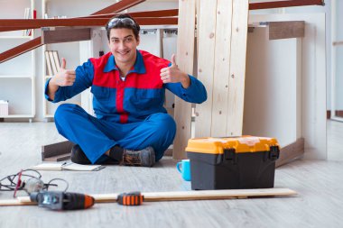 İnşaatta defter planlama yapan genç bir marangoz.