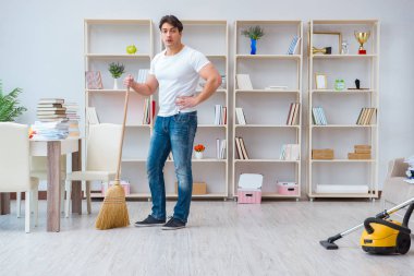 Adam evi temizliyor.