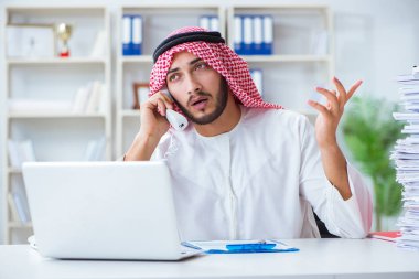 Ofiste çalışan Arap işadamı bir Pi ile evrak işi yapıyor.