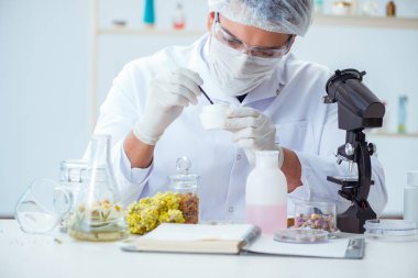 Laboratuvarda parfüm karıştıran bir kimyager.