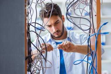 Elektrik teknisyeni tamir konseptinde kabloları çözmeye çalışıyor.