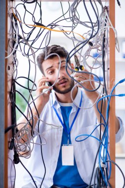 Elektrik teknisyeni tamir konseptinde kabloları çözmeye çalışıyor.