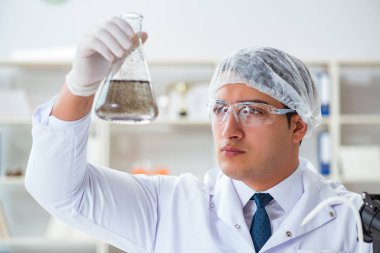 Genç araştırmacı bilim adamı bir su testi kirliliği araştırması yapıyor.