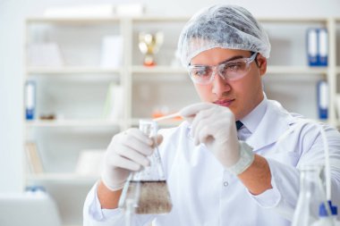 Genç araştırmacı bilim adamı bir su testi kirliliği araştırması yapıyor.