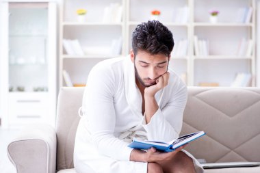 Öğrenci işadamı genç adam bir kitap okuyor.