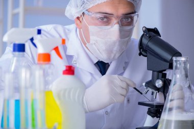 Laboratuvardaki adam yeni temizlik çözeltisi deterjanı test ediyor.
