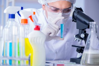 Laboratuvardaki adam yeni temizlik çözeltisi deterjanı test ediyor.