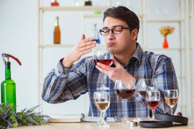 Profesyonel şarap garsonu kırmızı şarap tadıyor.