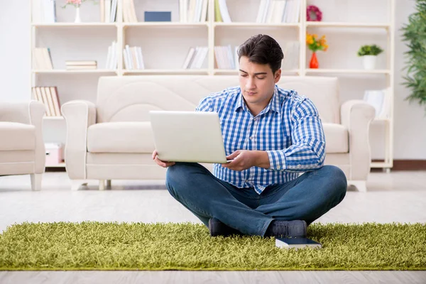 Junger schöner Mann sitzt zu Hause auf dem Fußboden — Stockfoto