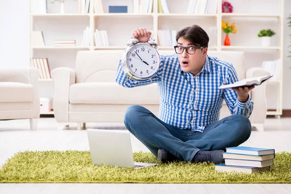 Genç yakışıklı adam evde yerde oturuyor.