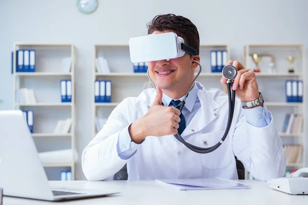 Νεαρός γιατρός με ακουστικά εικονικής πραγματικότητας που εργάζεται στο γραφείο — Φωτογραφία Αρχείου