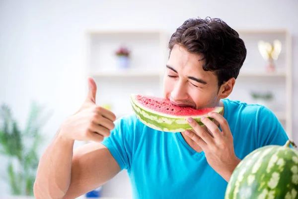 Man die thuis watermeloen eet — Stockfoto