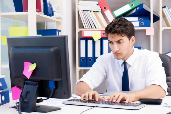 Ofiste kitap ve kağıtlarla çalışan bir işadamı.