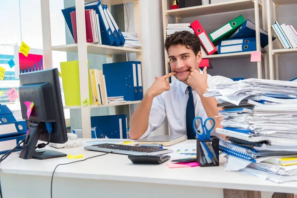 Geschäftsmann arbeitet im Büro mit Stapeln von Büchern und Papieren — Stockfoto