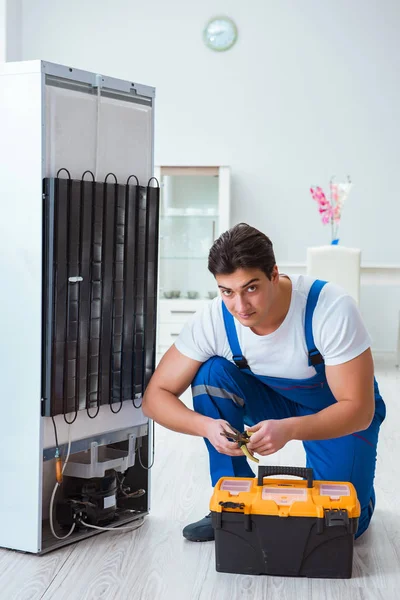 Tamirci müteahhit DIY konseptinde buzdolabını tamir ediyor.