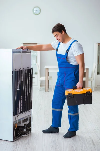 Repairman contractor repairing fridge in DIY concept