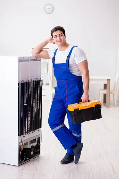 Repairman contractor repairing fridge in DIY concept