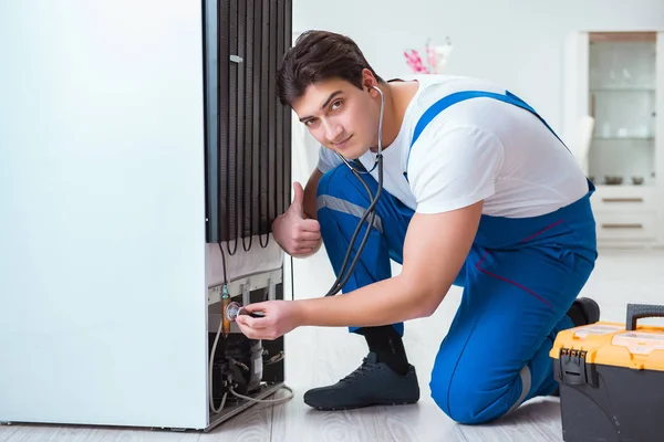 Reparador contratante reparação de geladeira no conceito DIY — Fotografia de Stock