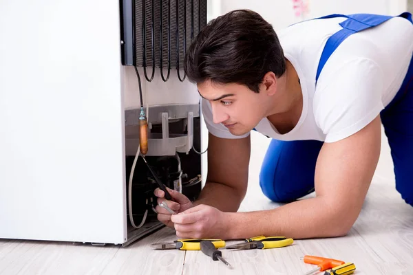 Tamirci müteahhit DIY konseptinde buzdolabını tamir ediyor.