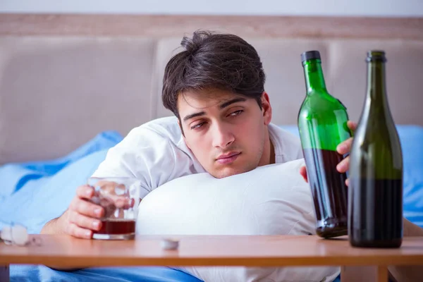 Hombre alcohólico bebiendo en la cama pasando por romper la depresión —  Fotos de Stock