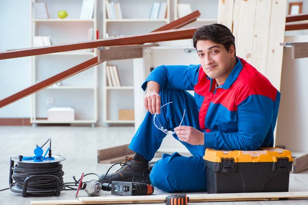 Genç marangoz ahşap kalaslarla çalışmaya ara veriyor.