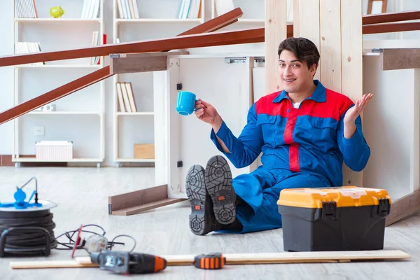 Genç marangoz ahşap kalaslarla çalışmaya ara veriyor.