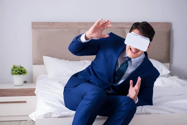 Empresário vestindo um fone de ouvido realidade virtual no quarto — Fotografia de Stock