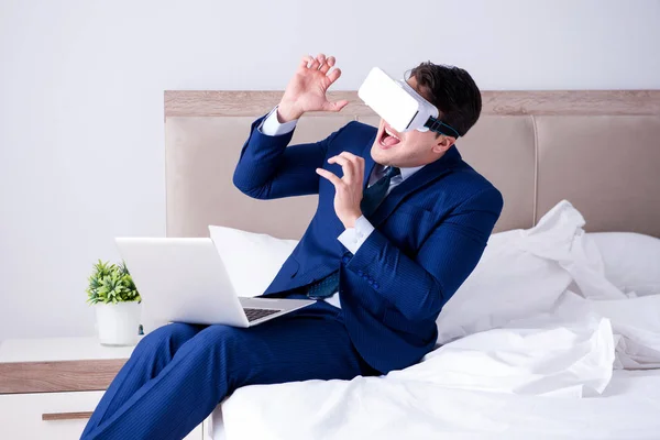 Empresário vestindo um fone de ouvido realidade virtual no quarto — Fotografia de Stock