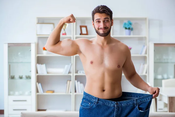 Человек в огромных брюках в концепции потери веса — стоковое фото