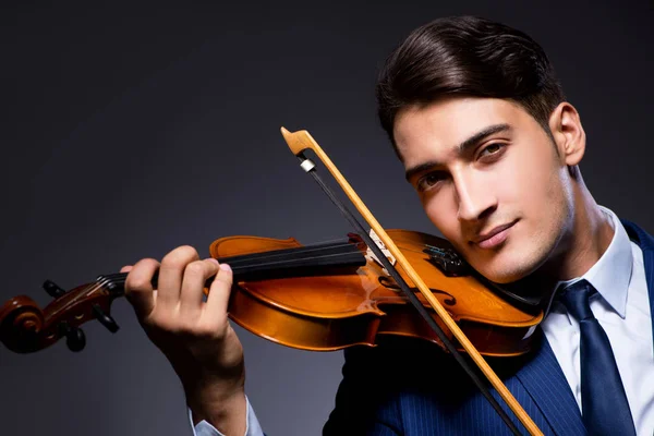 Jovem tocando violino no quarto escuro — Fotografia de Stock