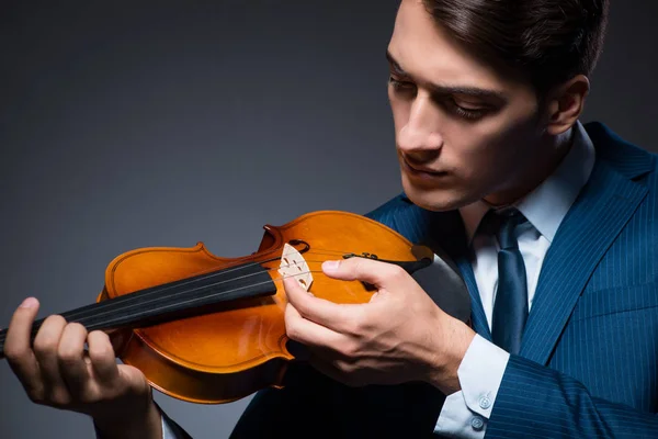 Jovem tocando violino no quarto escuro — Fotografia de Stock