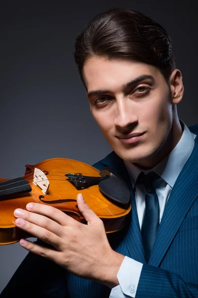 Jovem tocando violino no quarto escuro — Fotografia de Stock