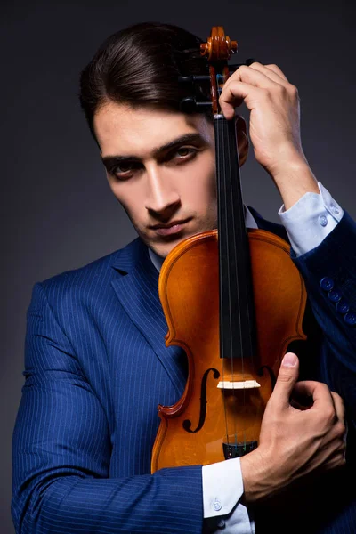 Jovem tocando violino no quarto escuro — Fotografia de Stock